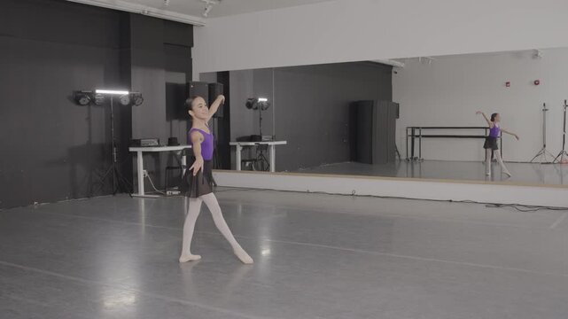 Acrobatic young female ballet dancers training in a modern dance studio