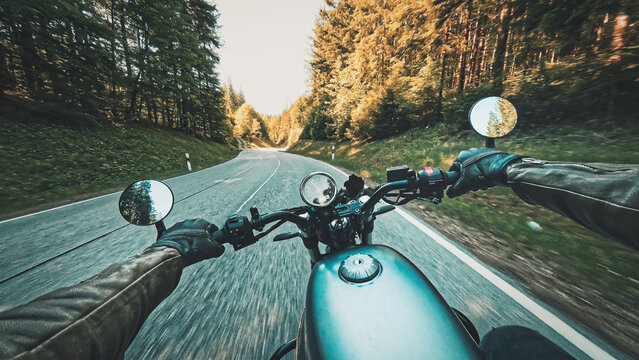 Riding classic retro motorcycle  naked bike on land road curves on sunny summer day - POV handlebar forward view in motion