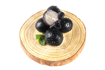 Fresh Dark Grapes with Water Drops on Natural Wood Tree Slice © VuVan
