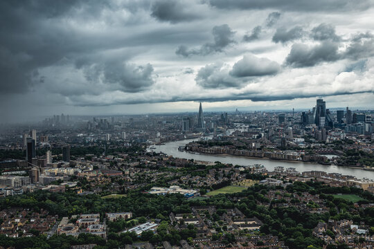 Elevated, panoramic landscape view of the London City skyline with dark clouds and rain approaching