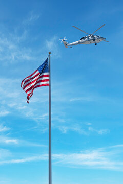 United States Navy Helicopter Flying Above American Flag On Sunny Day