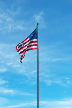American Flag Waving Against Blue Sky On Sunny Day
