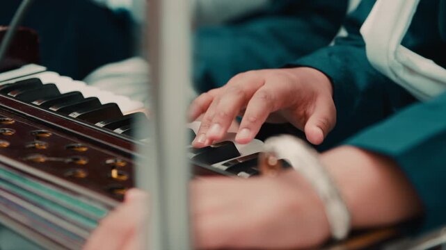Indian child hands plays Sikh prayer music with harmonium keyboard during Vaisakhi