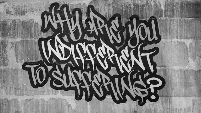 Black and white graffiti lettering on stone wall asking question about human indifference