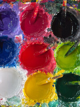 Thick paint wells with stirring sticks at a Chiang Mai studio