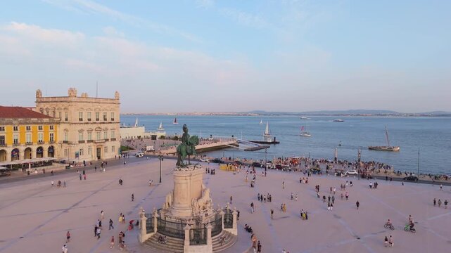 Lisbon City at Sunset. Commerce Plaza, Equestrian Statue, Tourists and Tejo River. Portugal. Aerial Drone Shot. Orbiting