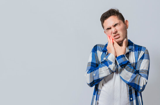 Man suffering with toothache or pulpitis isolated. Young man with sensitivity and toothache isolated. Tooth pain and sensitivity in people