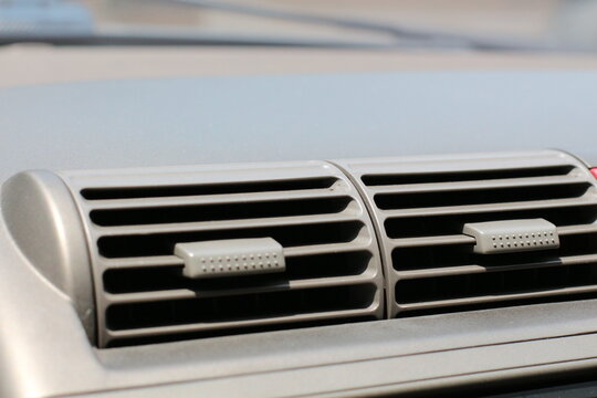 Close-up of a car's interior air conditioning vent on a sunny day
