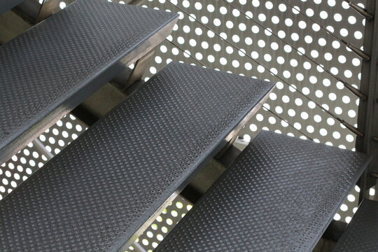 Modern metal staircase with perforated metal backing and safety treads