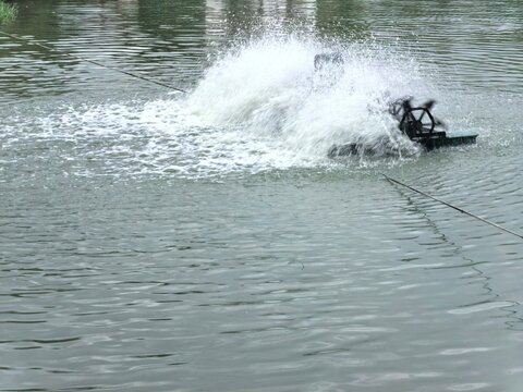 Water aeration turbine churning up a storm of white spray on the surface of a pond