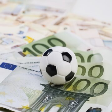 Football on euro notes, symbolic image for a betting scandal in professional soccer sport, AI generated