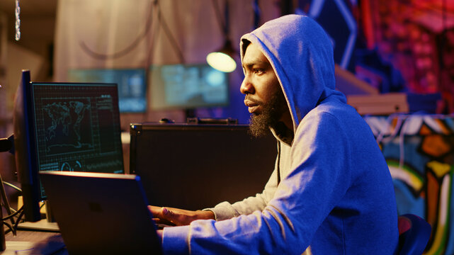 Hacker using VPN and darknet as anonymity tools to mask his online identity while committing data breaches, Cybercriminal in underground bunker masking his location hacking into servers.