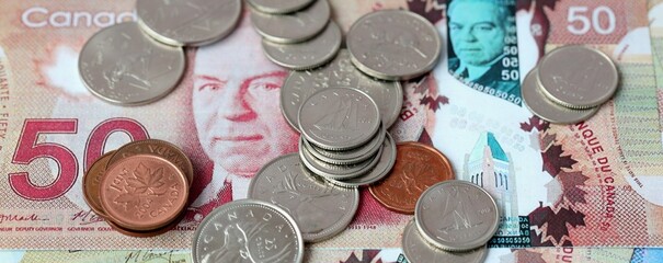 Naklejka premium Canadian dollar money bills and coins on table. Canada cash of CAD currency close up