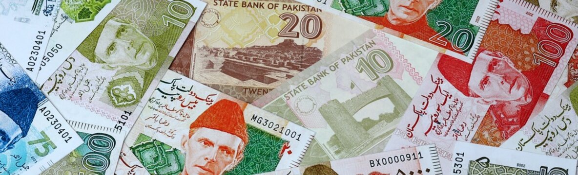 Pakistani rupee money bills in pile on table. Pakistan PKR currency cash close up