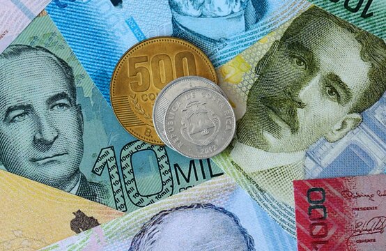 Costa Rican colon money banknotes and coins on table. Costa Rica cash bills of CRC currency