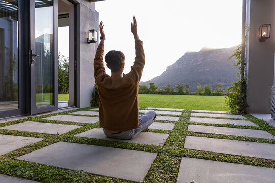 Concrete square pavers are forming grid on patio while sun is backlighting distant mountain ridge
