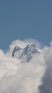 Vertical shot of Fishtail Mountain (Machhapuchhre) Peak Emerging Through Dramatic Clouds | Annapurna Himalayas, Nepal 4K