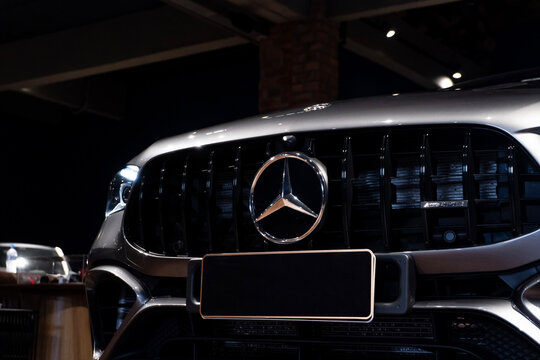 Grey Mercedes CLA 45 S front grille and logo close up, Luxury sport sedan front end detail in showroom