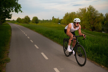 Naklejka premium Young man cyclist riding bicycle in the summer nature