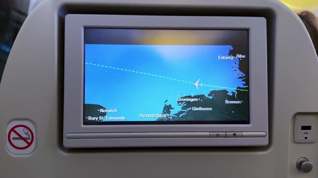 In-flight screen displays airplane flight path over Europe, highlighting cities and trajectory, providing a visual representation of the journey