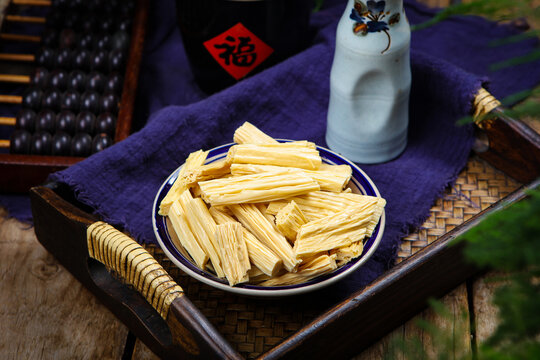 Dried Tofu Skin Sticks on Rustic Tray with Traditional Asian Tableware