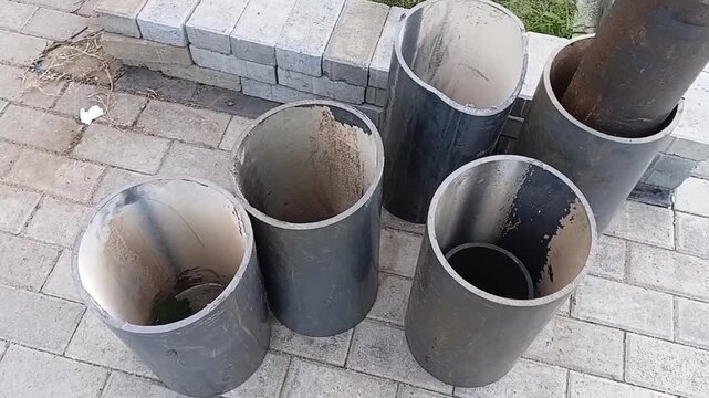 Discarded Large PVC Water Pipes Showing Heavy Calcium Carbonate Scale Buildup Inside After Plumbing Maintenance