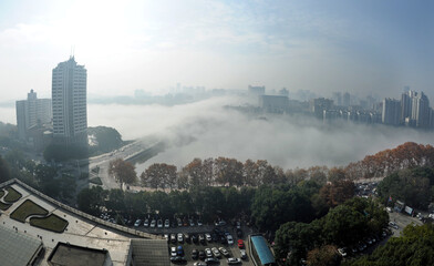 Morning fog over urban lake and skyline in Wuhan, China © NguyenMinh