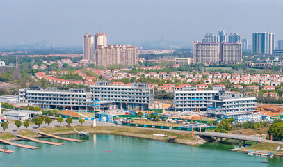 Naklejka premium Lakeside urban construction site with residential skyline