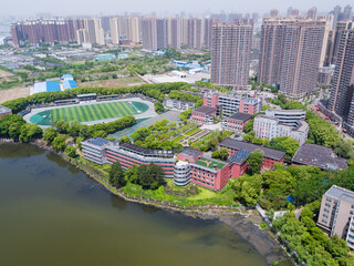 Aerial View of Urban High School Campus Beside Lake and Residential Towers © PhamHong