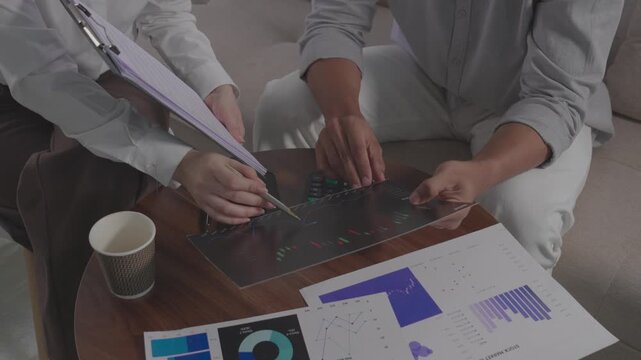  Client pointing at document during business contract signing meeting.Close up of hands reviewing financial insurance contract agreement details.