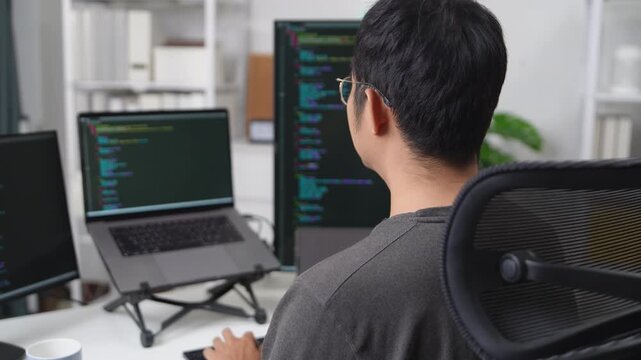Focused Developer Working Remotely on Multiple Monitors with Coding Display in a Modern Office Environment