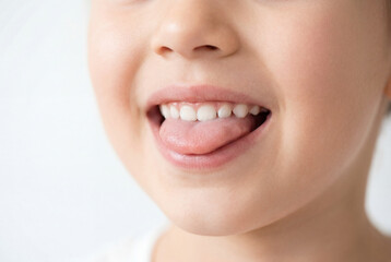 Fototapeta premium Close up of a healthy young child opening mouth and extending a clean pink tongue