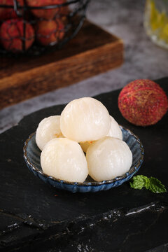 Fresh Peeled Lychees on Ceramic Dish with Whole Fruits