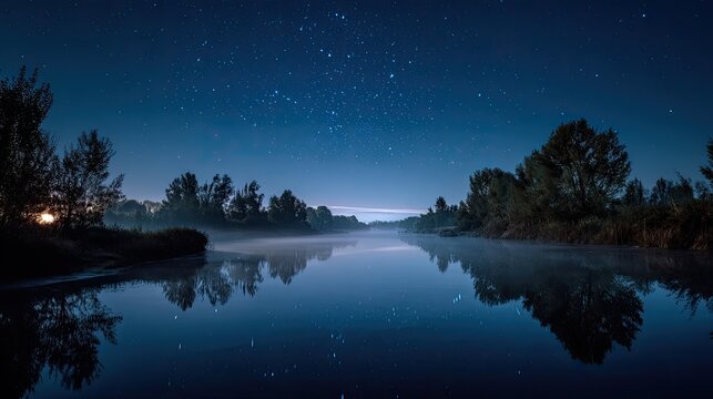 Serene night sky over a misty river reflecting stars and trees