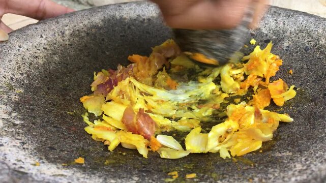Grind garlic, shallots and turmeric using a stone mortar