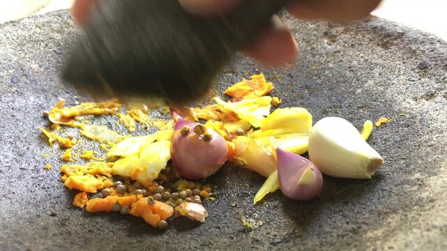 Grind garlic, shallots and turmeric using a stone mortar