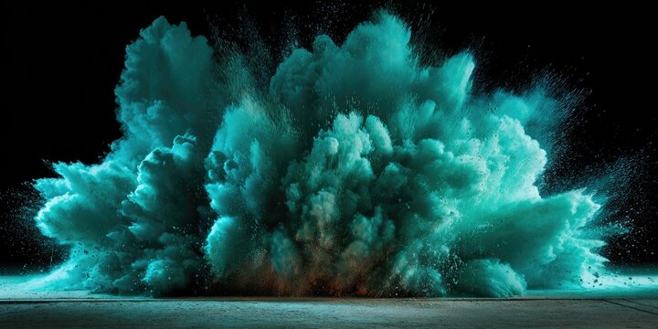 Teal powder exploding outwards against a dark background, creating a cloud