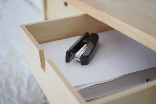 Stapler and papers in an open drawer at home office
