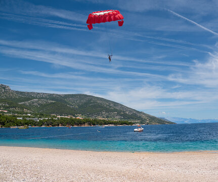 Tourist enjoying parasailing over the sea in Bol,Brac island,Croatia