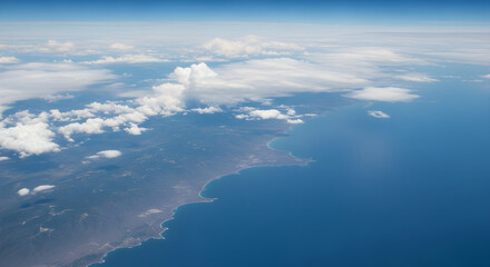 Fototapeta premium Aerial view of coastline with clouds floating above land and sea