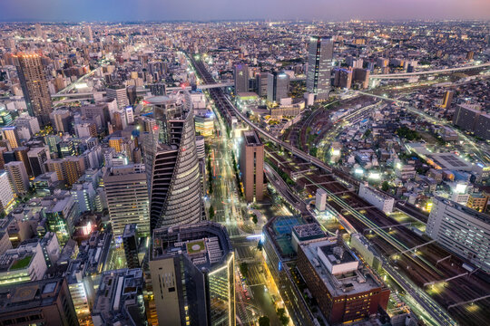 Nagoya central business district skyline on the evening, modern skyscrapers, roads and railways under twilight sky.