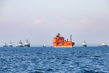 Fototapeta premium Industrial cargo ships and offshore supply vessels anchored at open sea near port harbor maritime terminal area