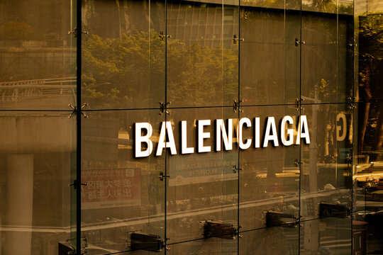 Guangzhou, China - January 18, 2026: Balenciaga sign illuminated on contemporary glass building exterior, reflecting cityscape. Iconic fashion label branding