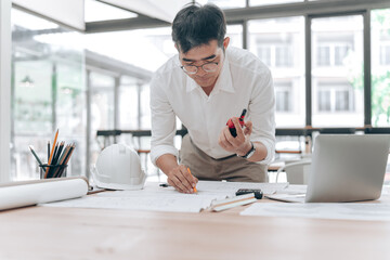 Architect Working with Blueprints and Measuring Tools in Modern Office Space © phaitoon
