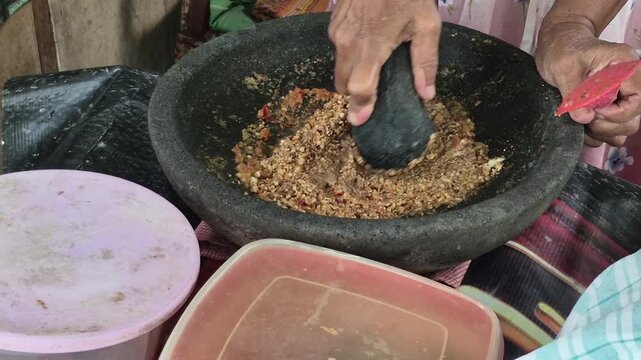 Peanut sauce is made using a traditional stone mortar. The spices are coarsely ground to maintain the crunchy texture of the peanuts and provide a refreshing taste