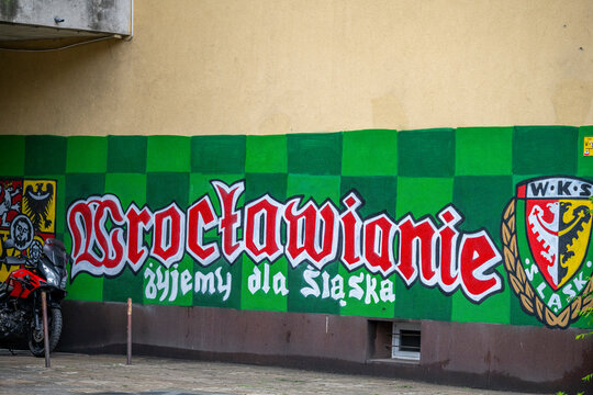 Wroclaw, Poland - June 06, 2026: Slask Wroclaw football fans mural featuring Wroclawians and We Live for Slask text alongside the club emblem on a wall