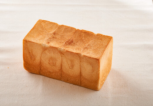 Freshly Baked Whole Pullman Loaf Bread on Textured Linen Tablecloth
