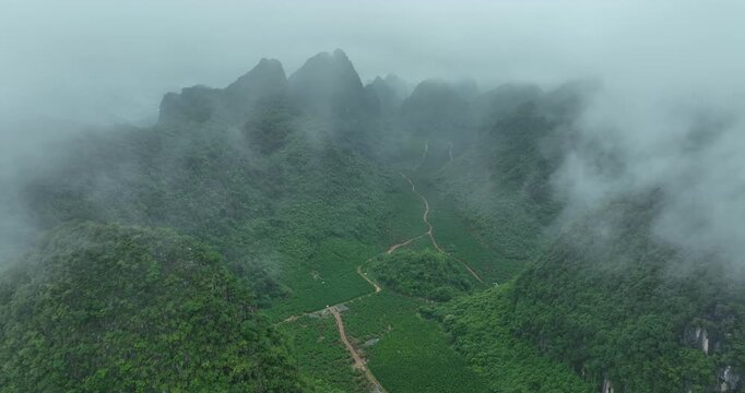 Aerial footage of beautiful sunrise over foggy karst mountain peak landscape