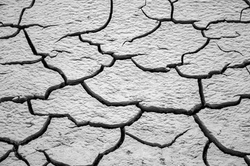 Texture of dry cracked river silt with deep fissures. This grey mudcrust background is perfect for 3D mapping, graphic design, desert concepts, and abstract weathered surface patterns.