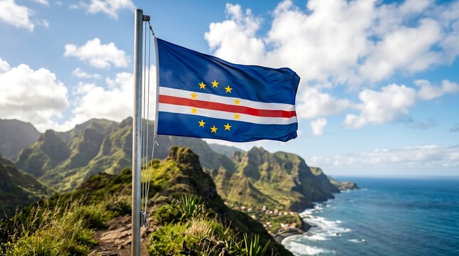 Cape Verde national flag waving on metal pole against green mountainous coastline and blue sky landscape